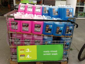 Photo of pink and blue screenwash outside Halfords. The more expensive 'advanced' version is pink.